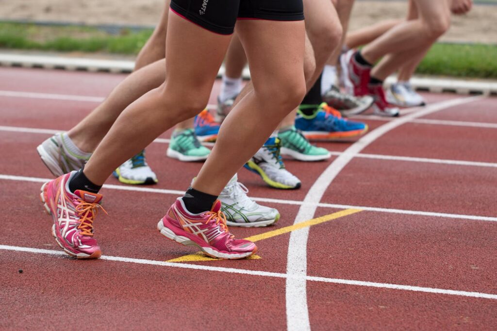 Close-up of athletes' feet at the starting line, prepared for a track race.
